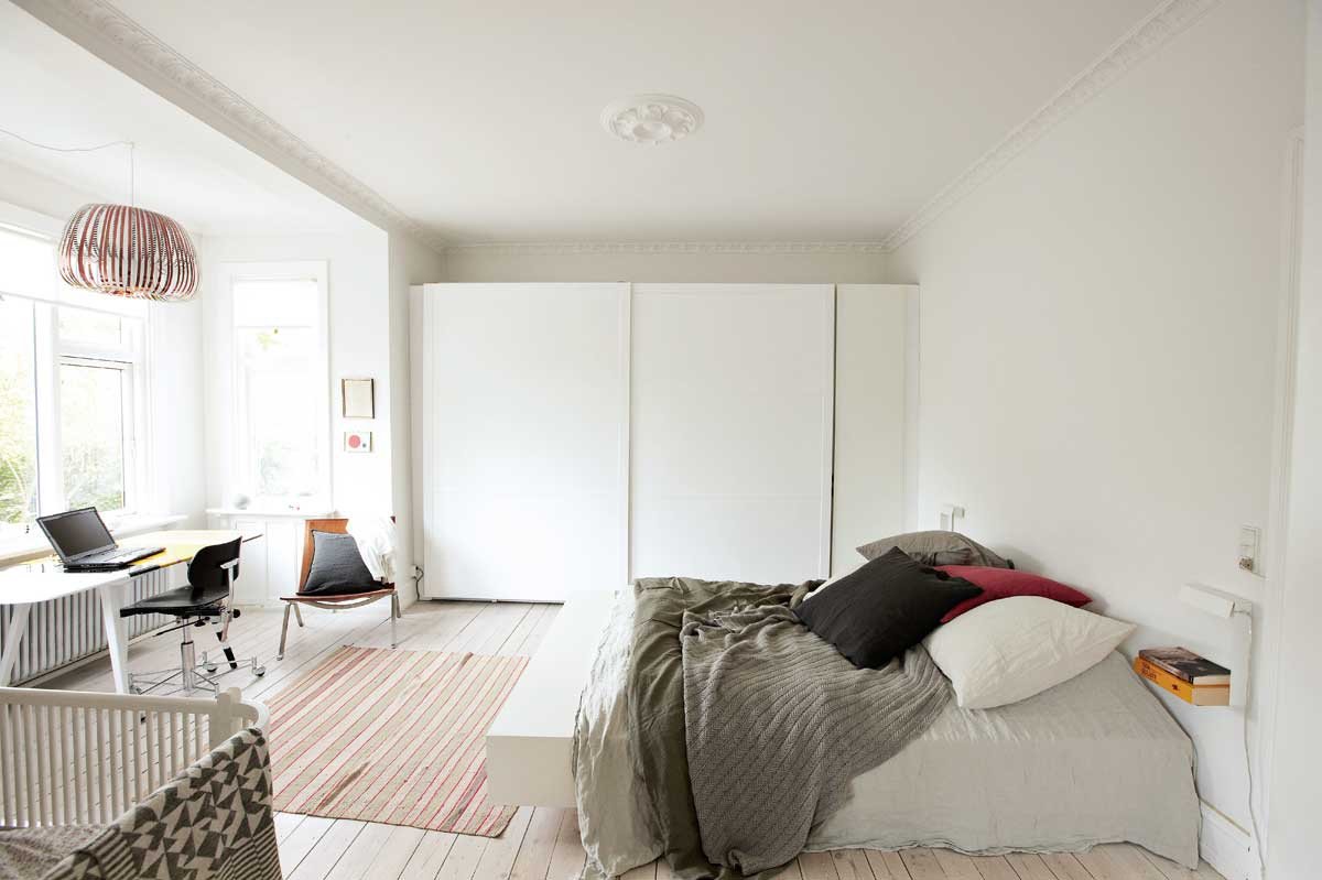 The bedroom is painted white and calm, neutral colors