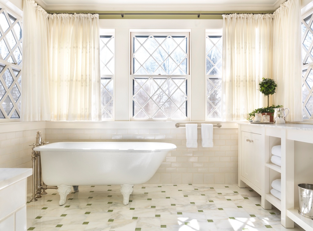 Traditional master bathroom with white, free-standing tub. White vanity and tiled floors.