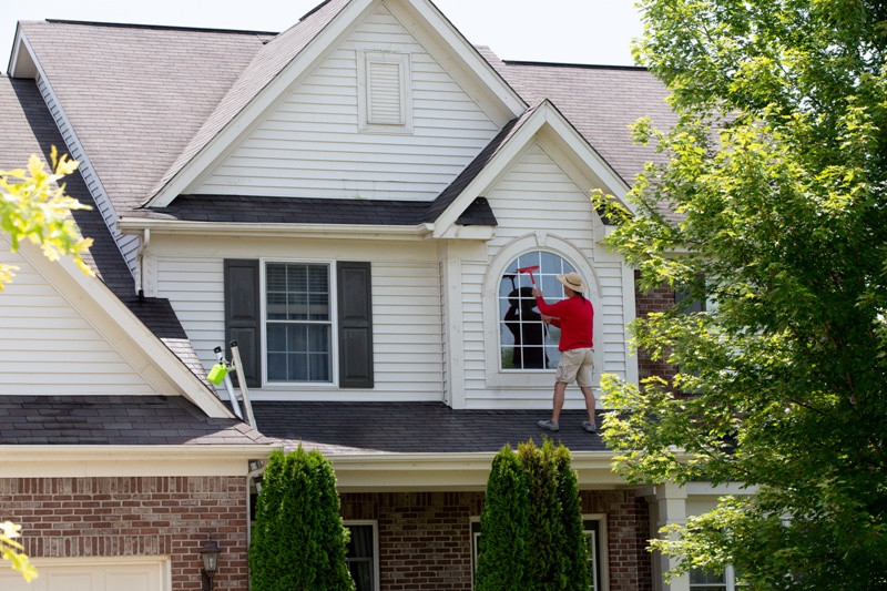 House proud man cleaning the upper floor windows