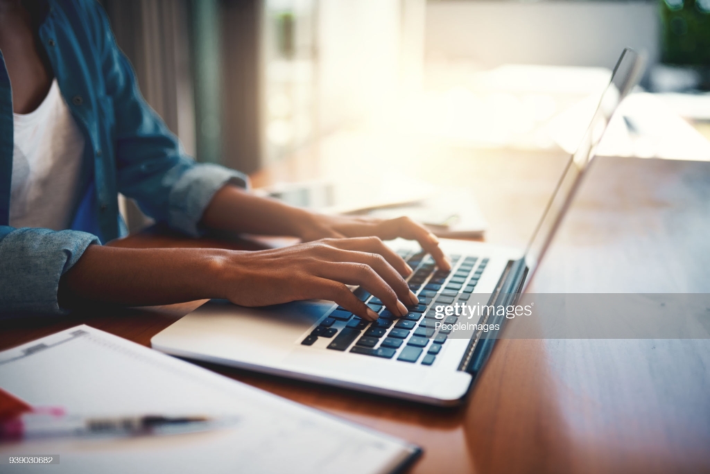 Closeup shot of an unrecognizable woman using a laptop while working from home