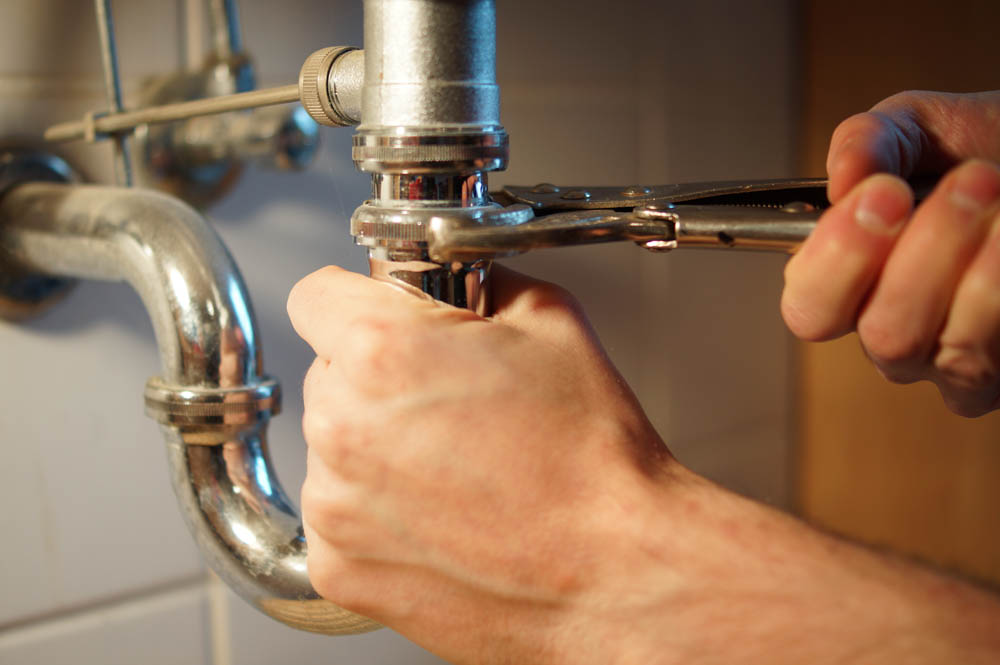 Plumbing repair service. Professional installer with spanner che