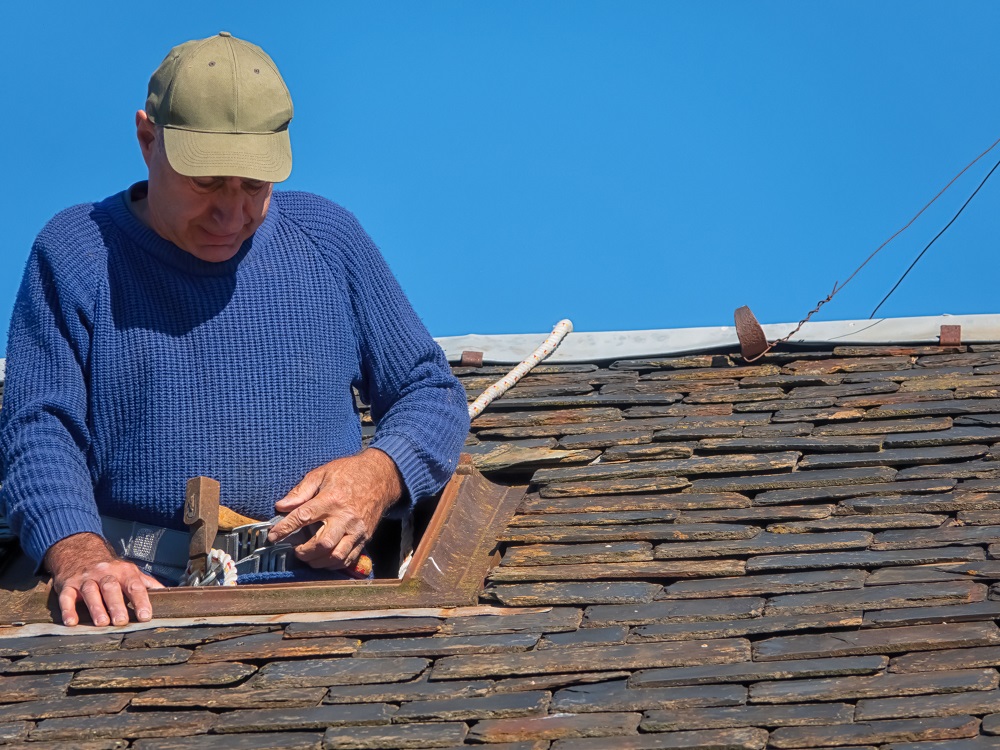 Maintenance of the roof of an old village house with slate tiles.