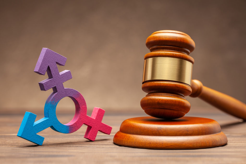 Transgender symbol and judge gavel on brown background. Concept