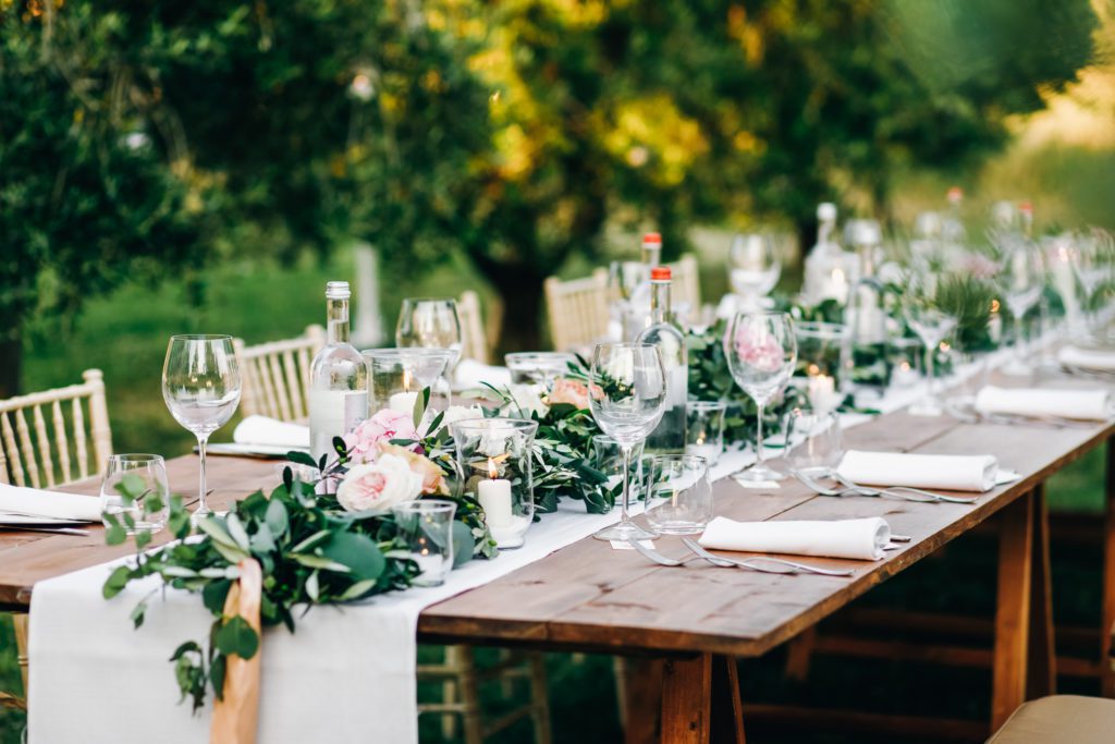 Floral garland of eucalyptus and pink flowers lies on the table
