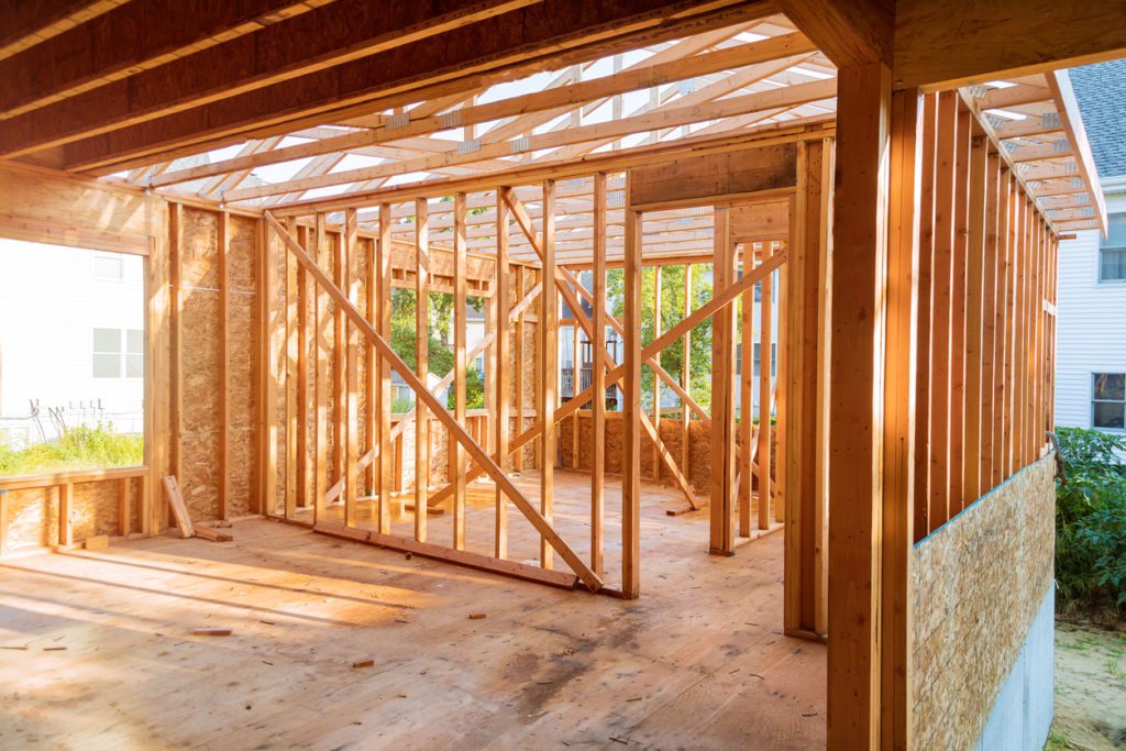 Konstruksi bangunan, bingkai kayu rumah baru di bawah atap konstruksi sedang dibangun