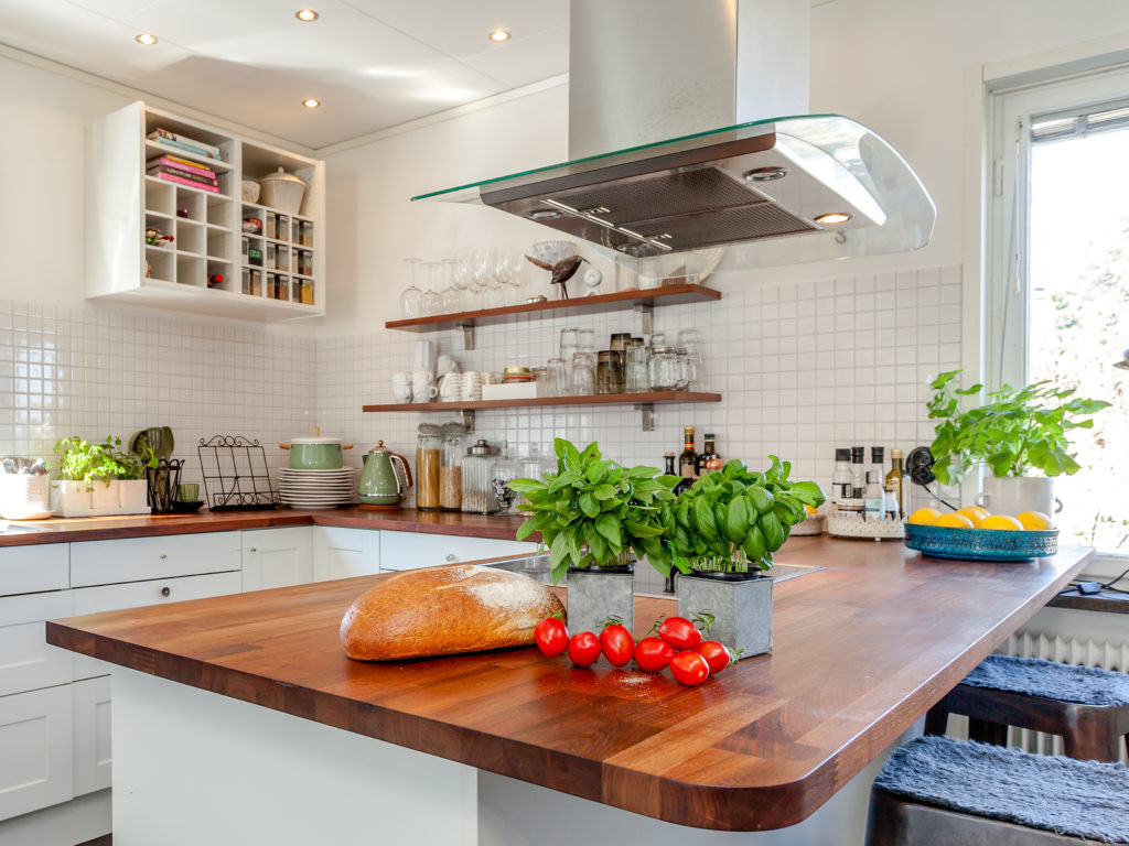 tomatoes, basil and fresh brad on the counter top with kitchen i