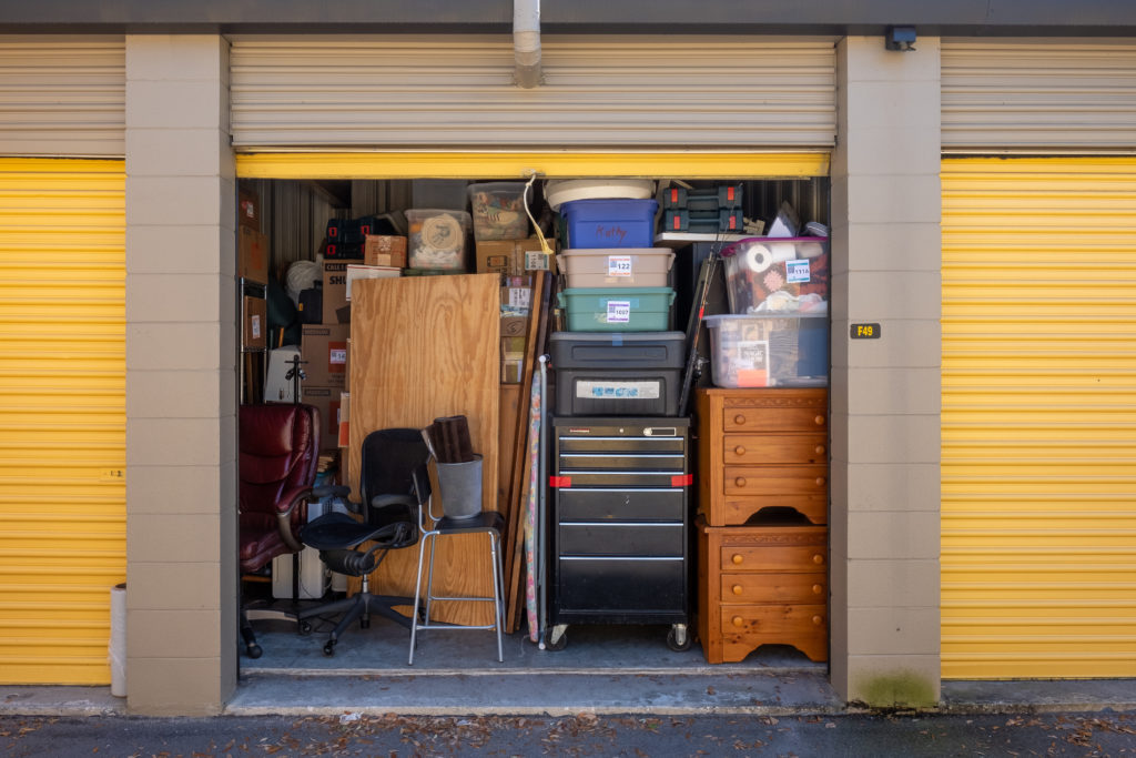 Contents of a house packed into a storage unit with the door ope