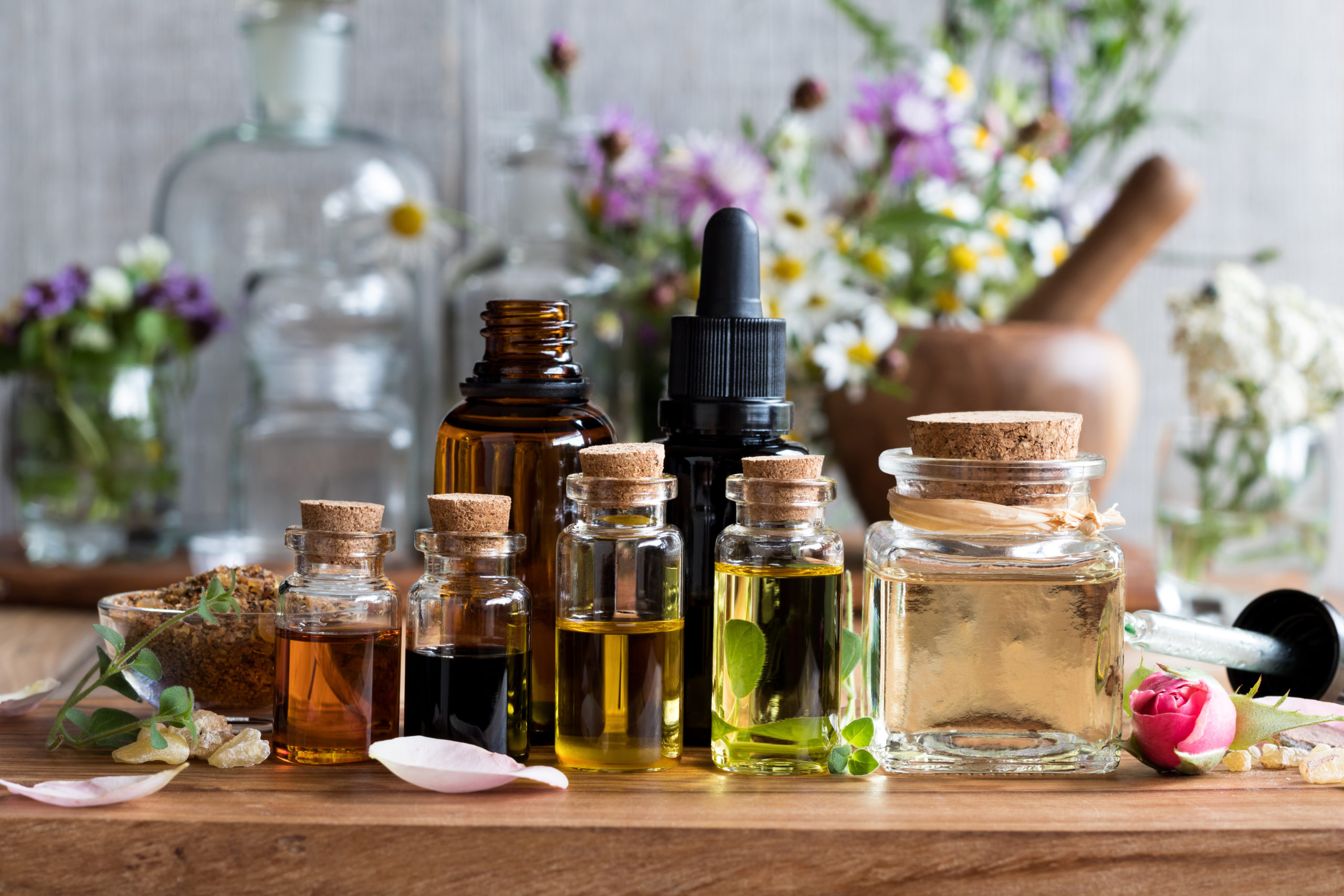 Selection of essential oils with herbs and flowers