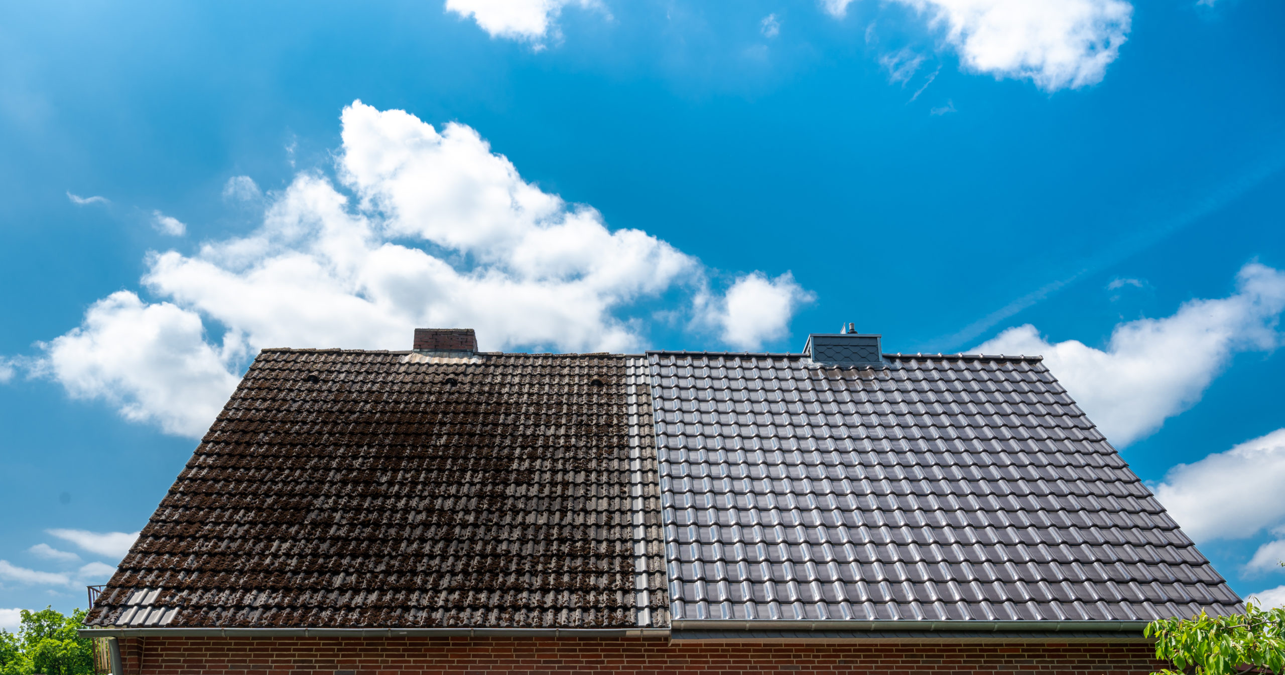 A half cleaned house roof shows the before and after effect of a