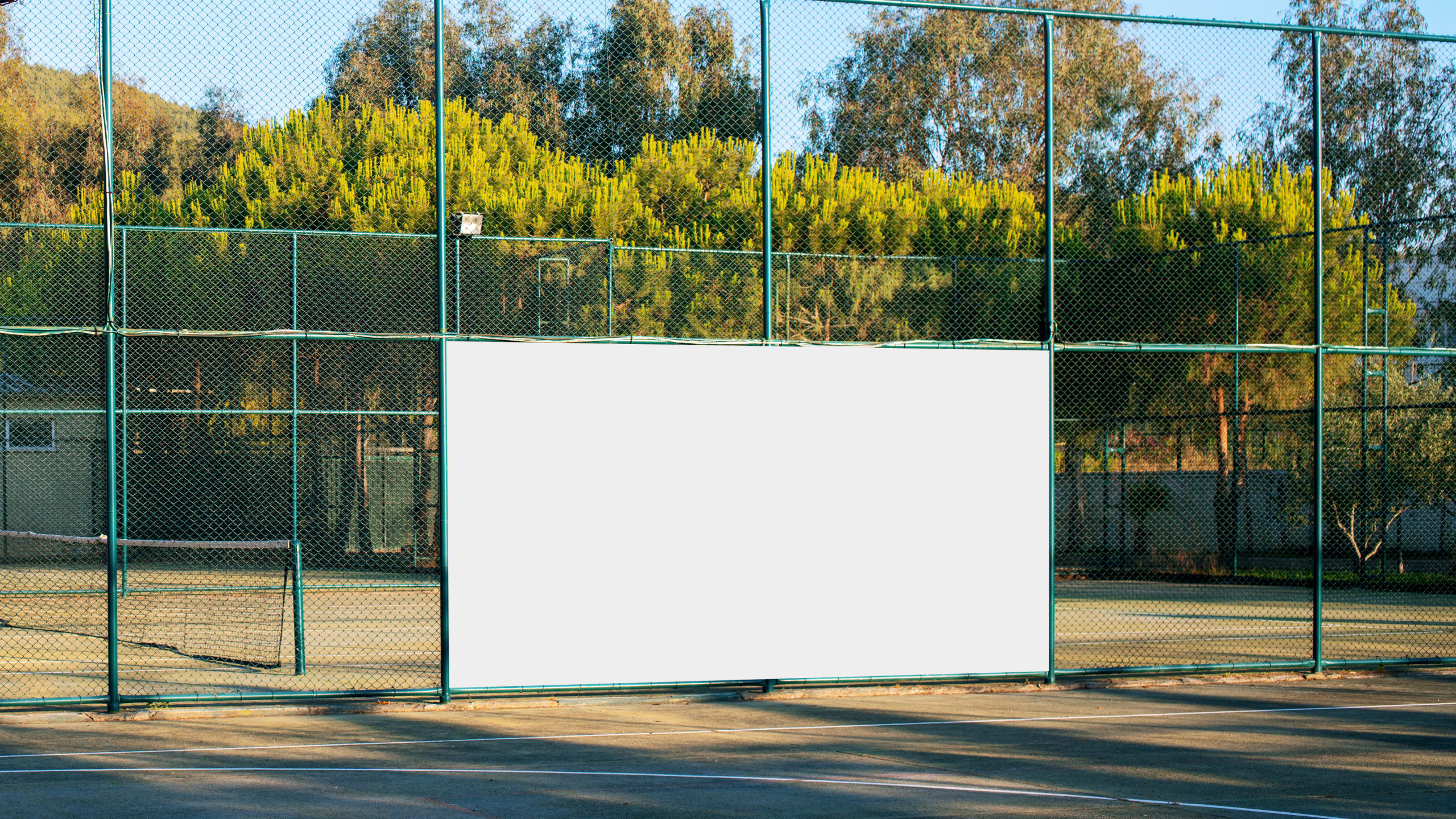 spanduk iklan putih kosong dengan mockup di pagar besi di lapangan olahraga