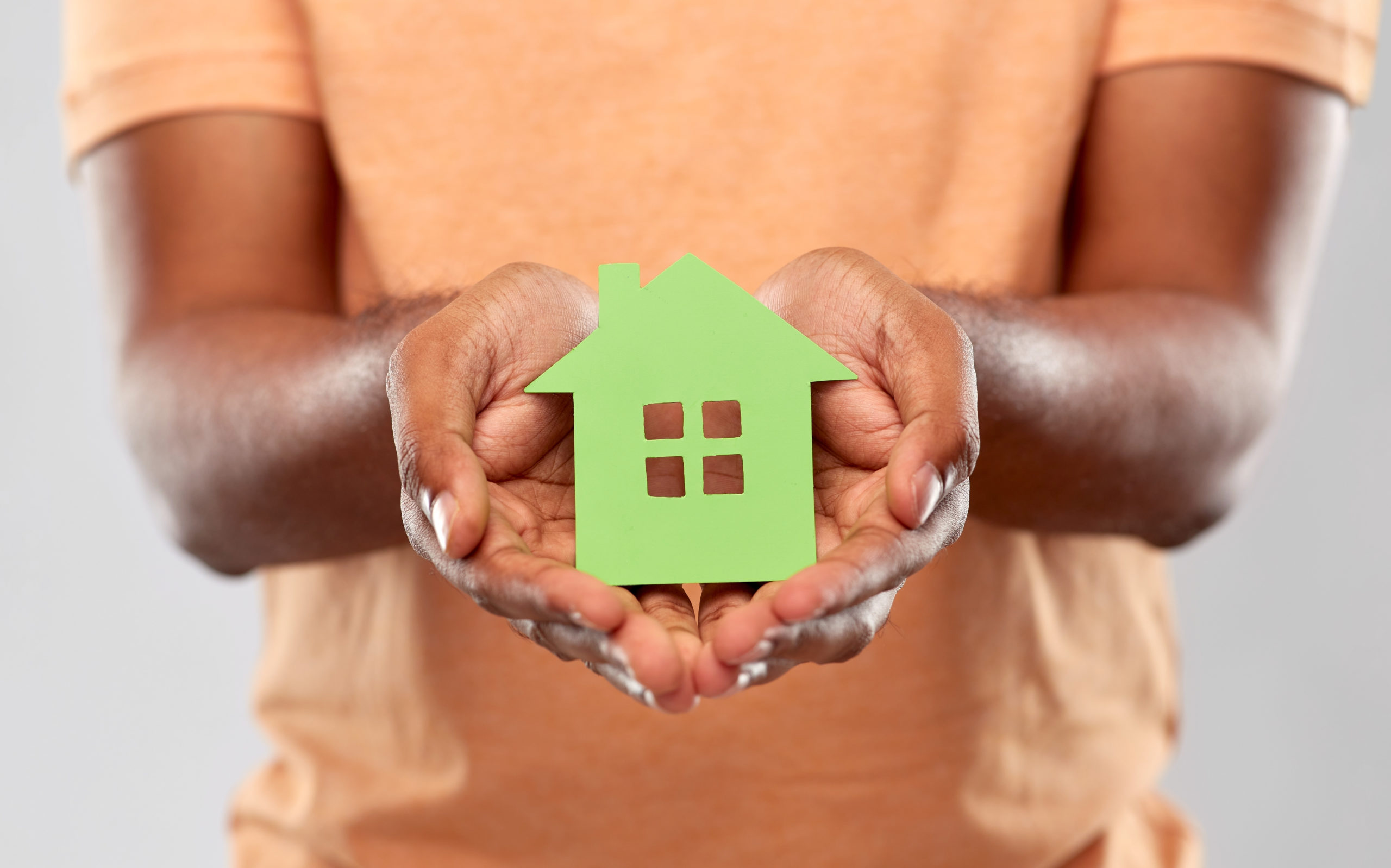 close up of african man holding green house