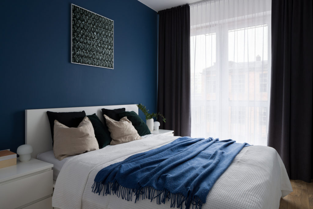 Comfortable bedroom with modern blue wall