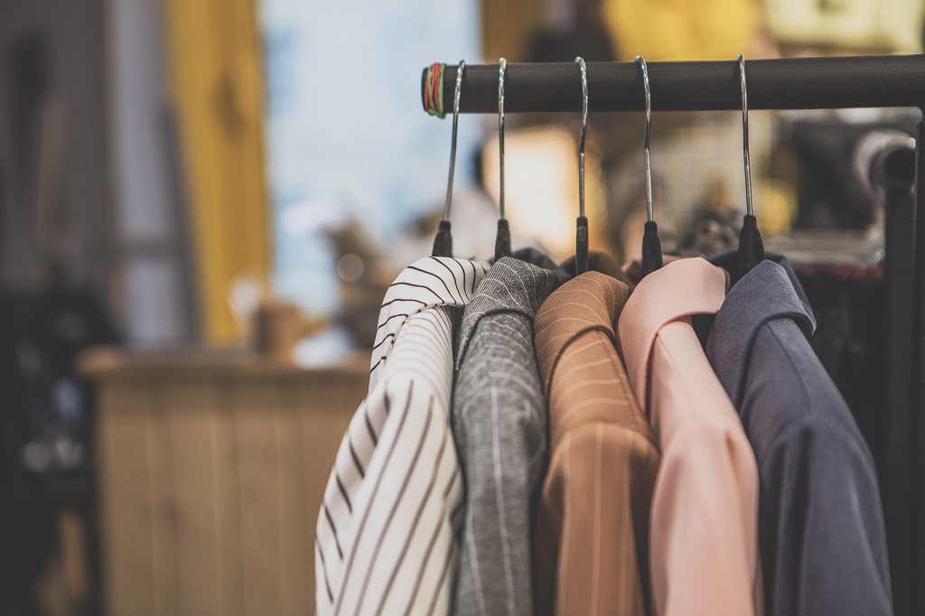 a lot of clothes hangers that are closely located next to each other in a store with women’s clothing, an atmosphere of women’s space with a large selection of colorful clothes