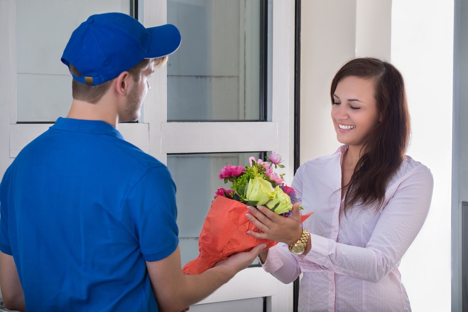 Smiling woman receives flowers from same day flower delivery service