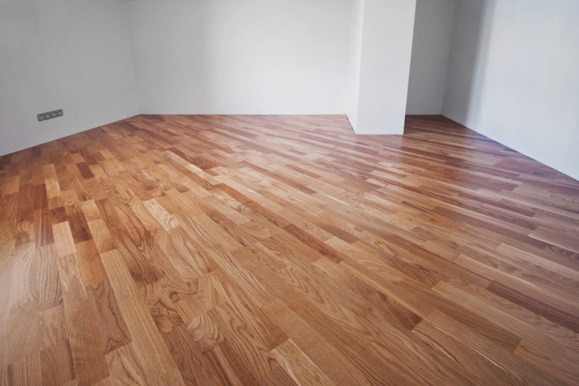 Flooring from a parquet oak board in an interior with bright light from a window
