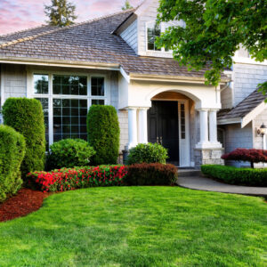 Beautiful home exterior in evening with healthy green lawn and f